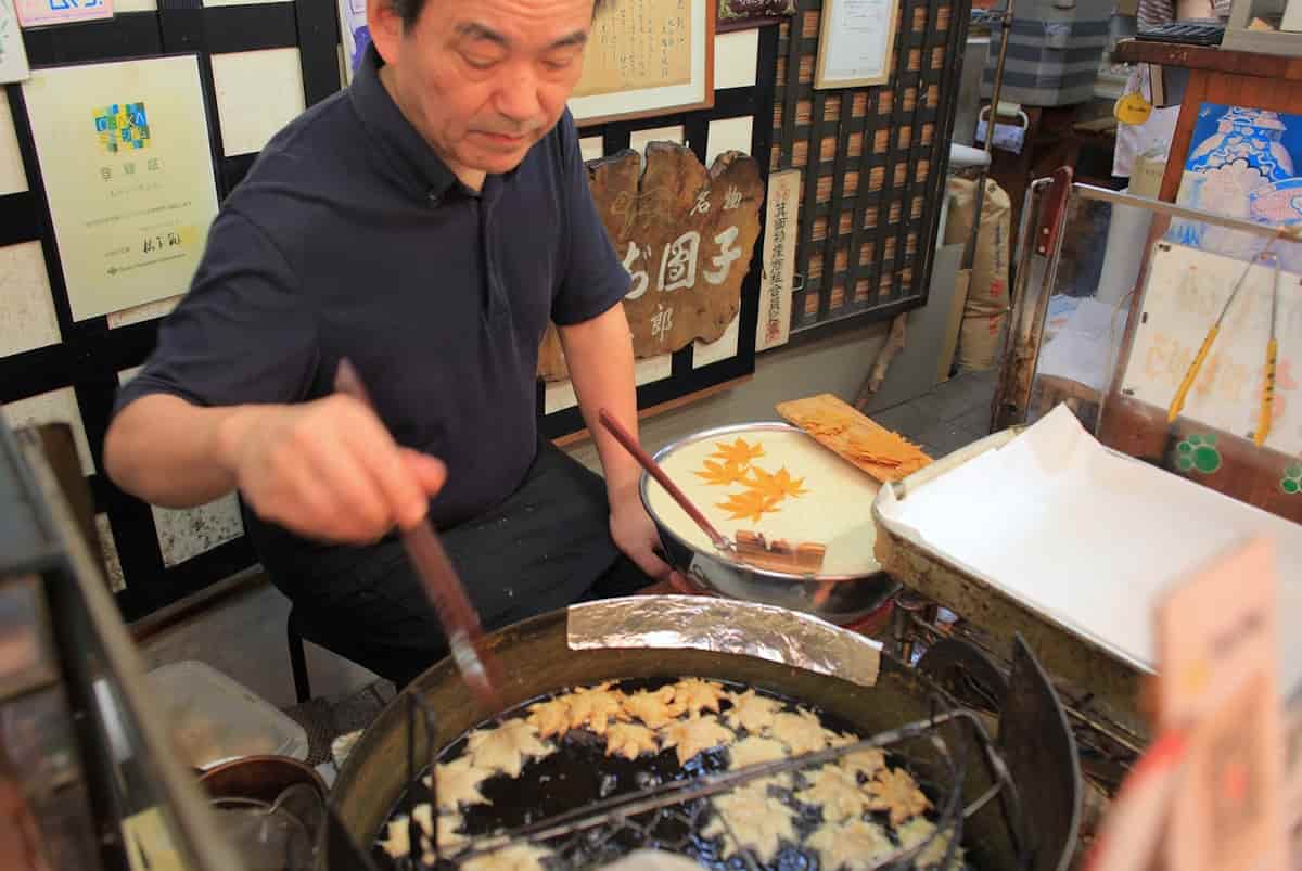 店頭でもみじの天ぷらを揚げる「桃太郎」の御主人、奥野さん