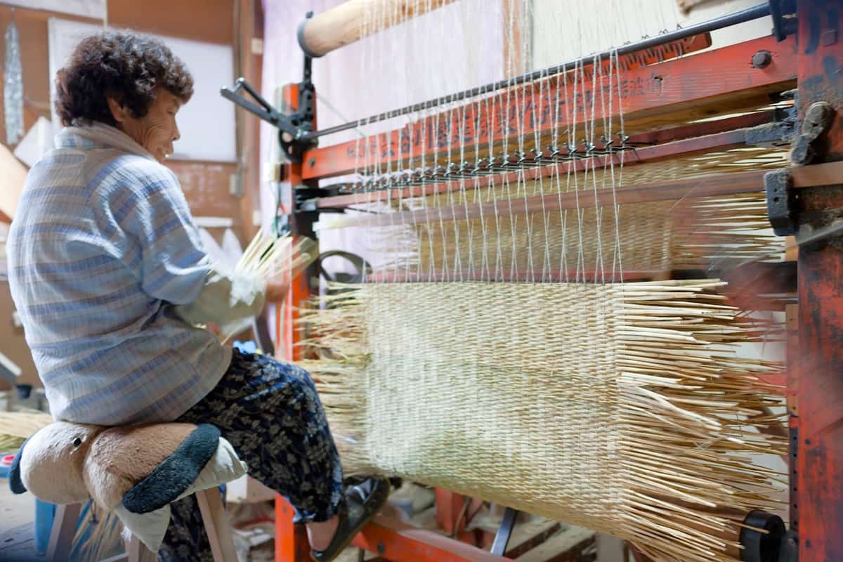 専用の織機を使って菰を織る。10年ほど前までは、この写真のように農家の内職だったが、現在は岸本吉二商店内で製造している