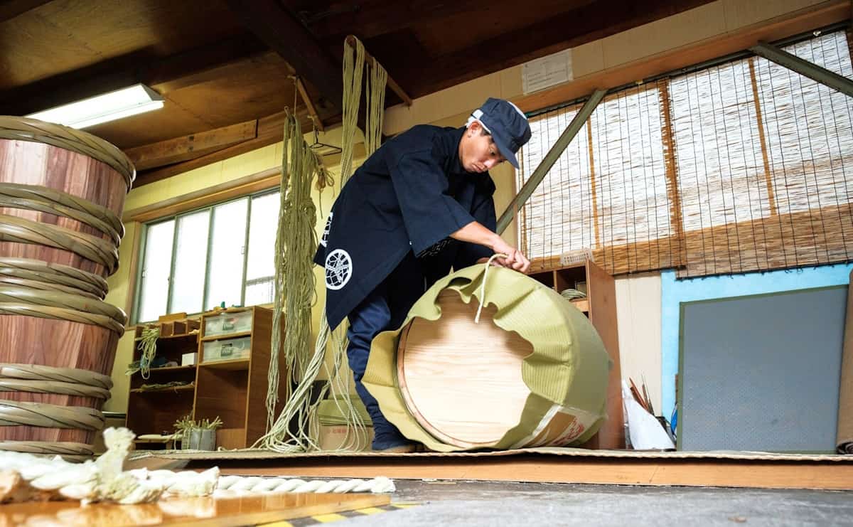 樽に菰を巻く職人を「荷師（にし）」と呼ぶ。慣れた荷師なら一樽を仕上げるのに10分ほど。ただし、慣れない人なら1時間かけてもできないことも